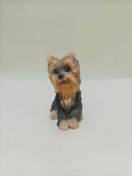A statue of a small sitting Wookiee dog in black and white, made of resin