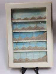 Sand game under glass in a white wooden frame