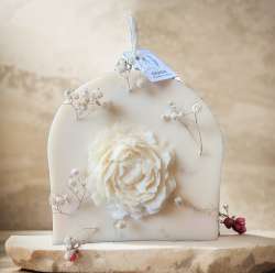 Rainbow candle decorated with natural roses