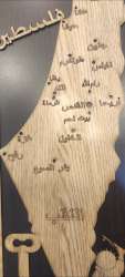 Carved wooden map of Palestine showing major cities, key symbol and child holdin