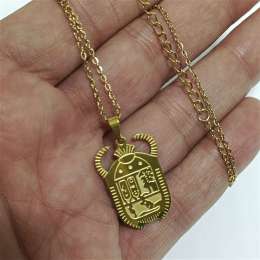 Gold-plated scarab pendant with engraved hieroglyphs in classic Egyptian style
