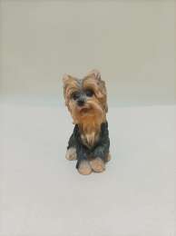 A statue of a small sitting Wookiee dog in black and white, made of resin
