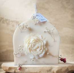 Rainbow candle decorated with natural roses