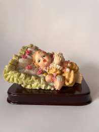 Figurine Of A Small Child On Pillow With Toys On Wooden Base Beautiful, Unique